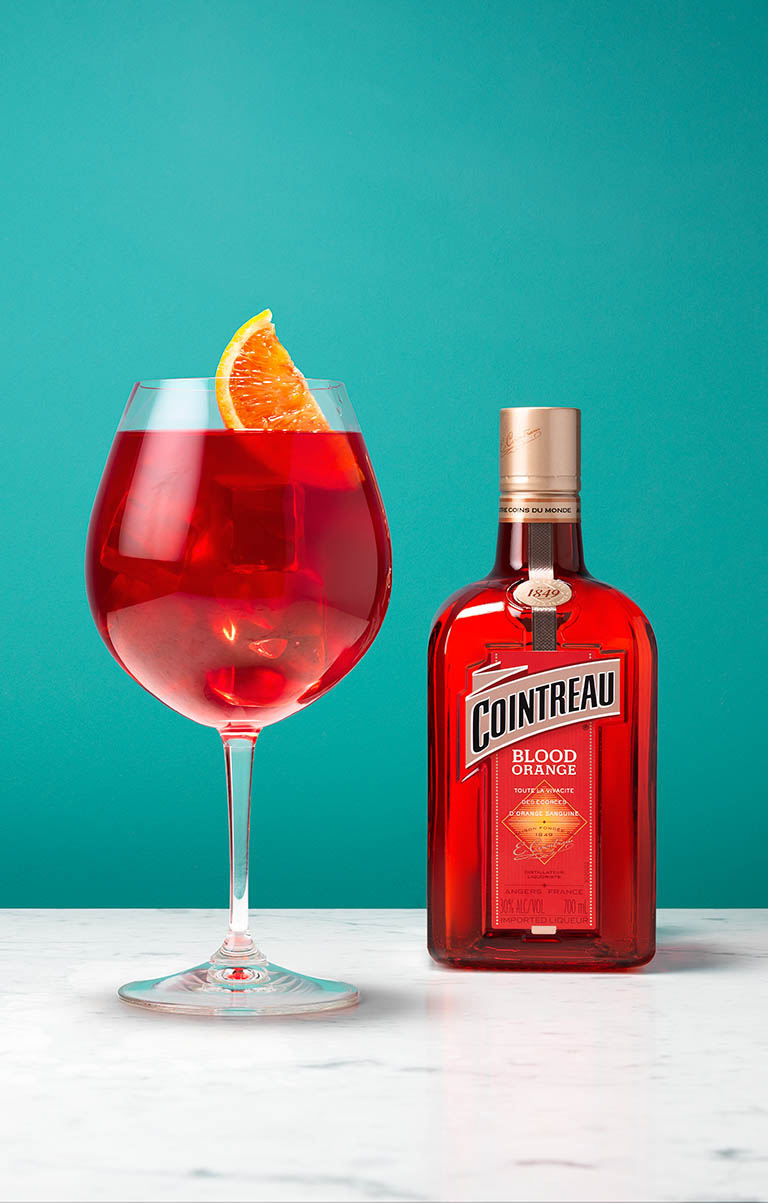 Packshot Factory - Coloured background - Cointreau Blood Orange bottle and cocktail serve