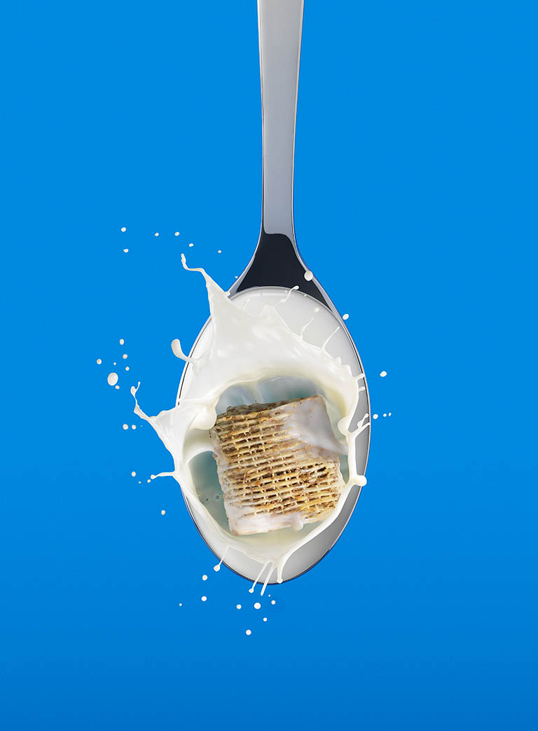 Food Photography of Koko milk shreddie bite on spoon with milk by Packshot Factory