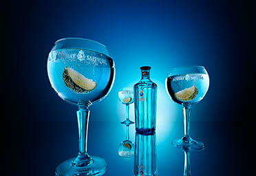 Coloured background Explorer of Bombay Sapphire gin bottle and serve
