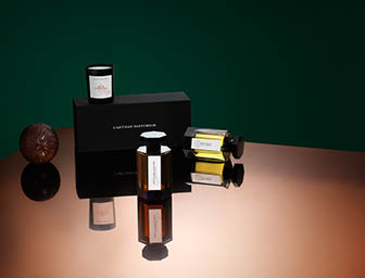 Coloured background Explorer of L'Artisan Parfumeur ambre ball and fragrance bottle