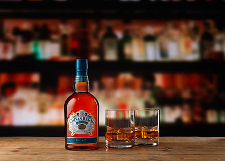 Coloured background Explorer of Chivas Regal whisky bottle and serve