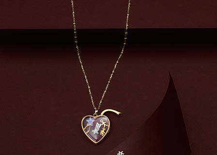 Coloured background Explorer of Loquet London gold chain with heart pendant