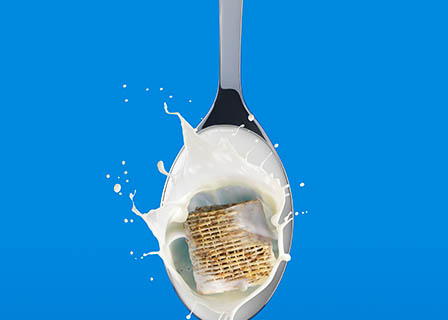 Food Photography of Koko milk shreddie bite on spoon with milk