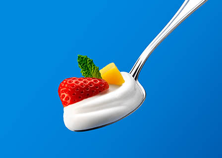 Food Photography of Koko yoghurt on a spoon with fruits